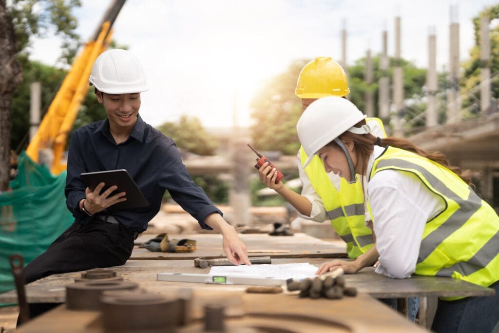 Young architects and engineer discussing blueprints at construction site.